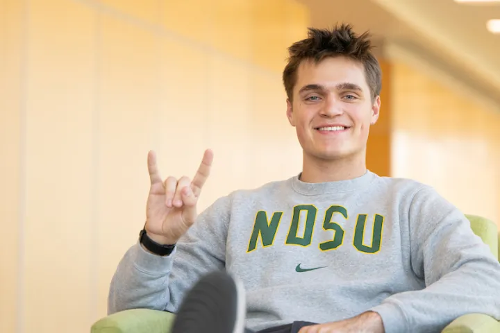 student giving Bison horns hand signal
