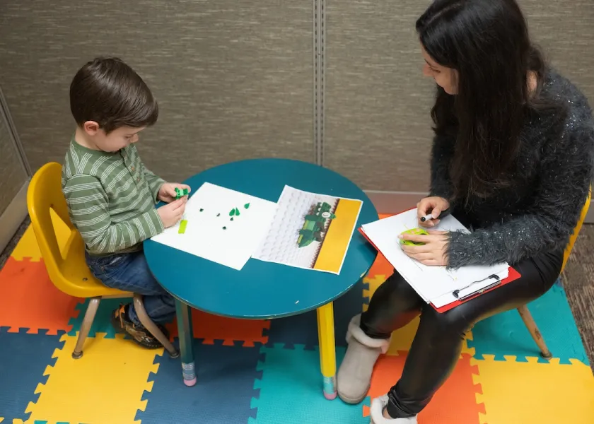 a child and NDSU student at small table