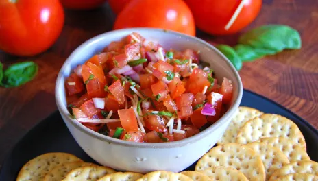 bowl of tomato bruschetta with crackers