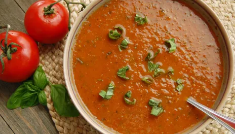 Rustic Tomato Basil Soup, prepared and served in a bowl with basil leaves on top