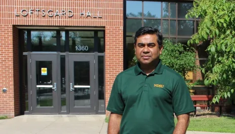 Shahidul Islam stands in fromt of Loftsgard Hall at NDSU