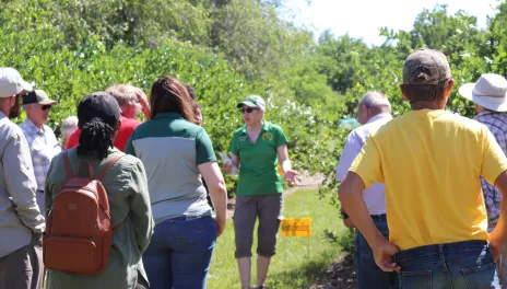 Kathy Wiederholt addresses a crowd of people at the CREC orchard.