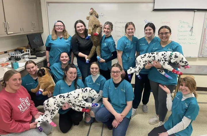 students in scrubs posing with stuffed animal dalmations 