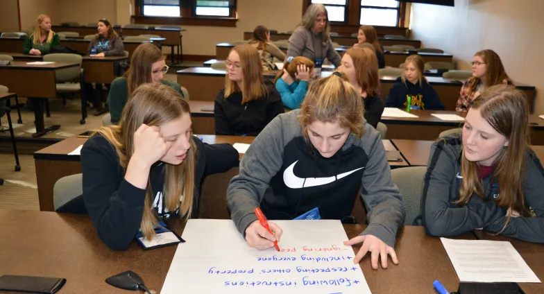 3 girls writing on large piece of paper