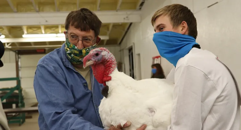 Man and boy with a white turkey