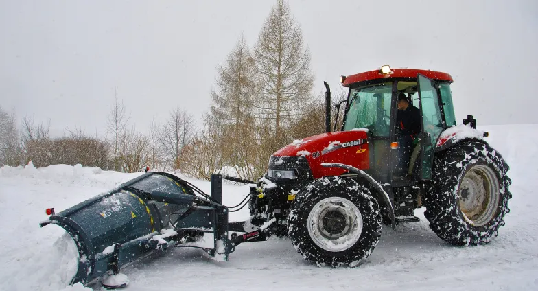 red tractor plowing snow