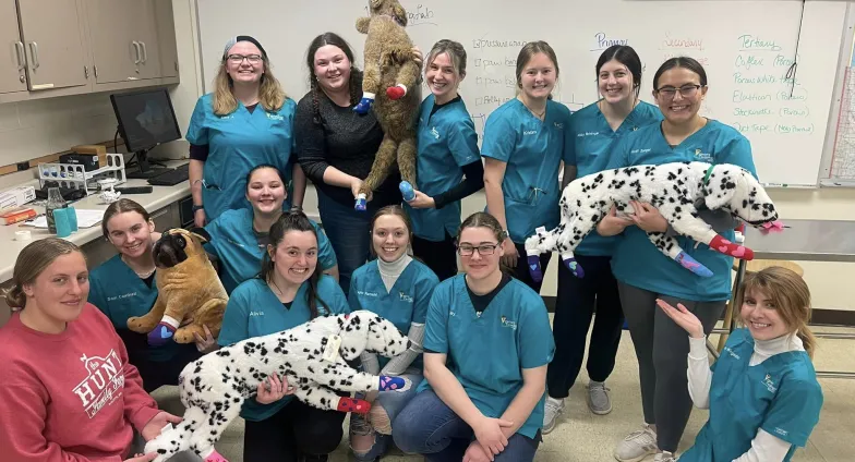 students in scrubs posing with stuffed animal dalmations 