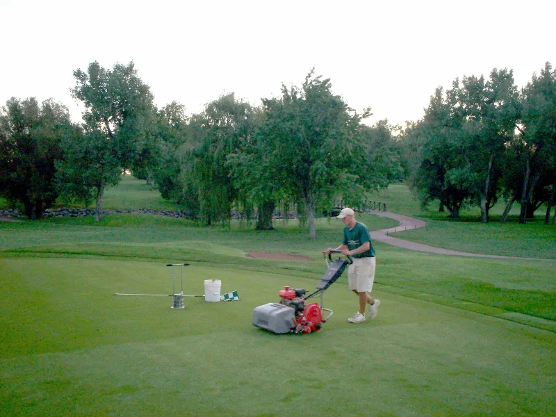 man mowing golf course grass