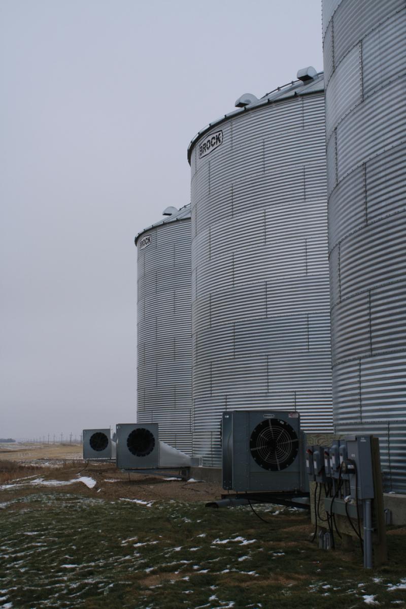 three grain bins with fans