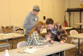 3 teens working closely on a project