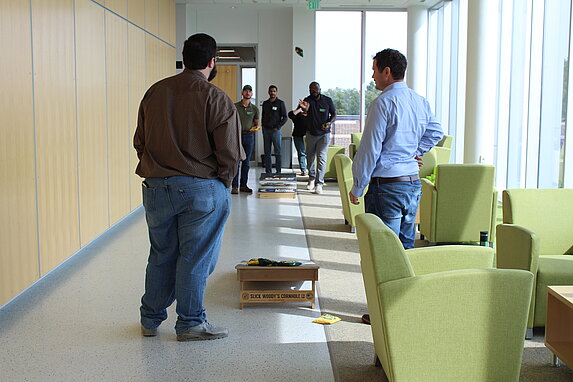 New faculty playing corn hole during adult recess.