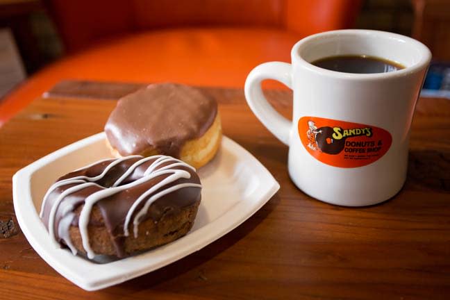 Donuts graphic with two donuts on a white plate and a cup of coffee on a red background