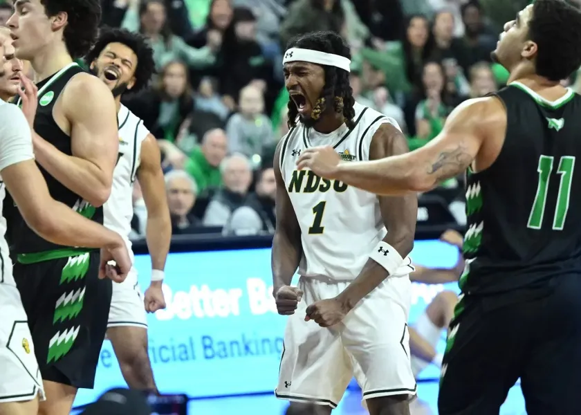 NDSU and UND men basketball players stand on the basketball court during the Summit League Tournament in Sioux Falls, South Dakota.