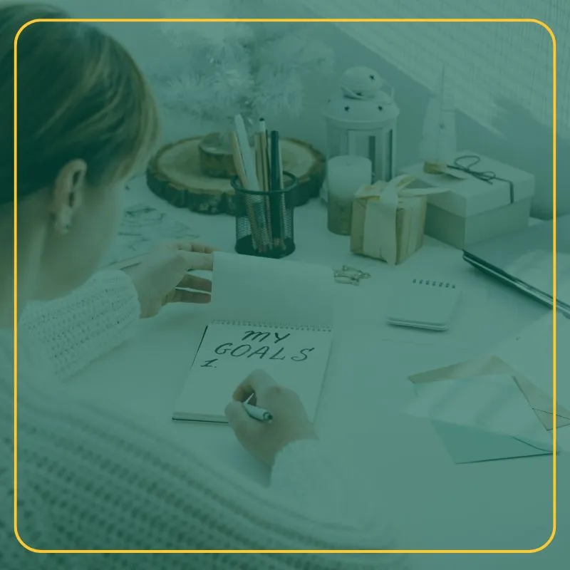 Person writing goals at their work desk