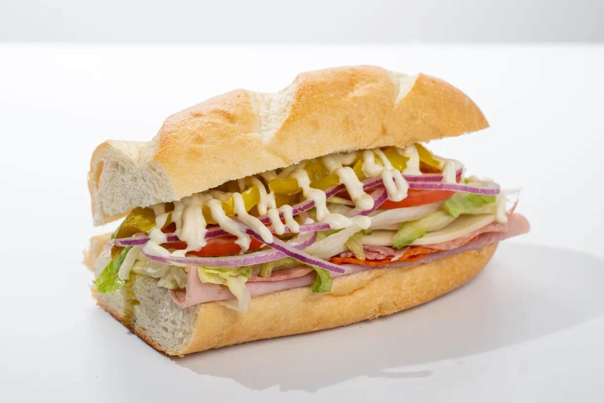 loaded cold deli sandwich with meat, vegetables, and mayo