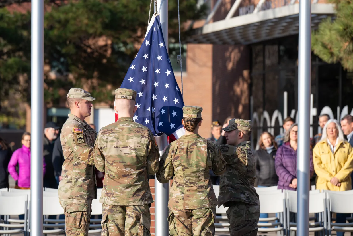 NDSU students part of the ROTC raise a flag at the flag post in front of the Memorial Union.